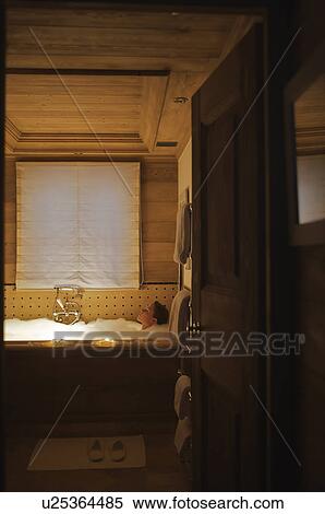 Stock Photography - Woman relaxing in bath at ski chalet. Fotosearch