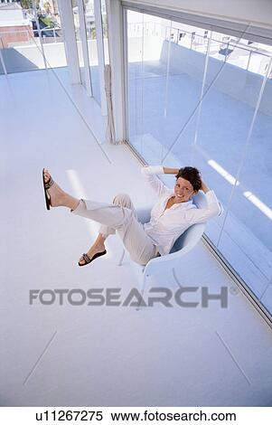 Stock Photography - Woman relaxing in office chair. Fotosearch