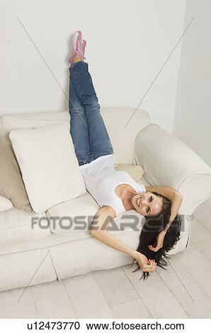 Woman relaxing on couch View Large Photo Image Stock Image - Woman relaxing on couch. Fotosearch