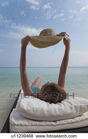 Woman relaxing on daybed at beach View Large Photo Image Stock Photo - Woman relaxing on daybed at beach. Fotosearch