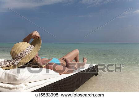 Woman relaxing on daybed at beach View Large Photo Image Stock Photography - Woman relaxing on daybed at beach. Fotosearch