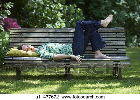 Woman relaxing on park bench View Large Photo Image Stock Image - Woman relaxing on park bench. Fotosearch