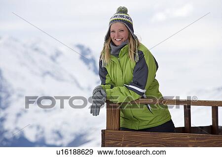 Stock Photo - Woman relaxing on ski lodge balcony. Fotosearch