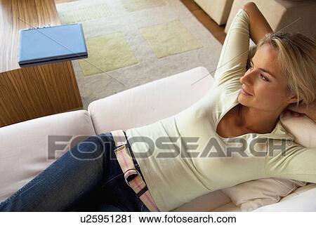 Stock Image - Woman relaxing on sofa. Fotosearch
