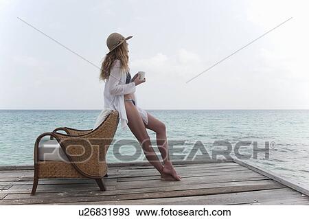 Woman relaxing with coffee on deck View Large Photo Image Stock Image - Woman relaxing with coffee on deck. Fotosearch