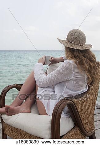 Woman relaxing with coffee on deck View Large Photo Image Stock Photo - Woman relaxing with coffee on deck. Fotosearch
