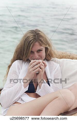 Woman relaxing with coffee on deck View Large Photo Image Stock Photo - Woman relaxing with coffee on deck. Fotosearch