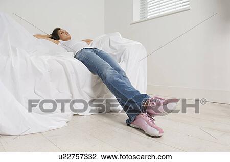 Woman resting on couch in new home View Large Photo Image Stock Image - Woman resting on couch in new home. Fotosearch