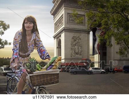 Woman riding bicycle by Arc de Triomphe View Large Photo Image Stock Image - Woman riding bicycle by Arc de Triomphe. Fotosearch