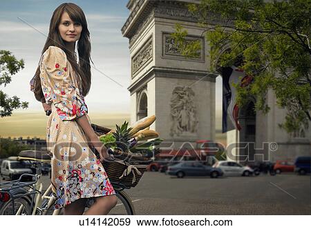 Woman riding bicycle by Arc de Triomphe View Large Photo Image Stock Photo - Woman riding bicycle by Arc de Triomphe. Fotosearch