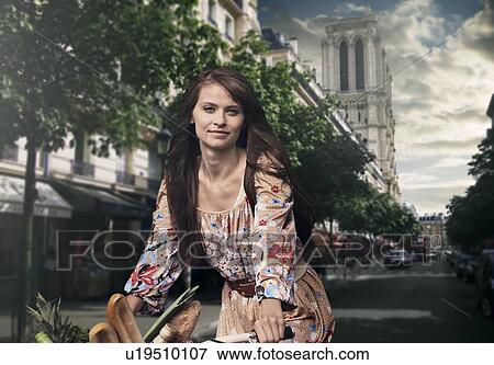 Stock Photo - Woman riding bicycle in town. Fotosearch