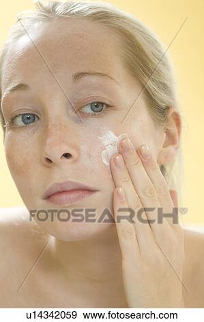Woman rubbing moisturizer on her face View Large Photo Image Stock Photo - Woman rubbing moisturizer on her face. Fotosearch