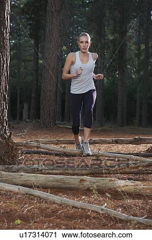 Stock Image - Woman running in forest. Fotosearch