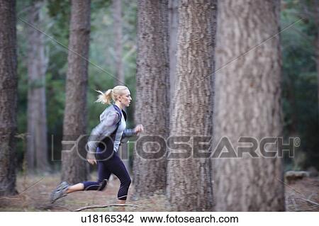 Woman running in forest View Large Photo Image Stock Image - Woman running in forest. Fotosearch