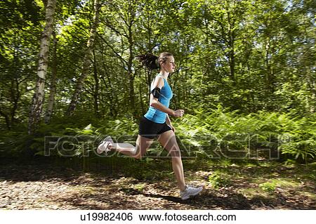 Stock Photograph - Woman running in forest. Fotosearch