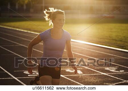 Stock Image - Woman running on track. Fotosearch