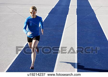 Stock Photo - Woman running on track. Fotosearch