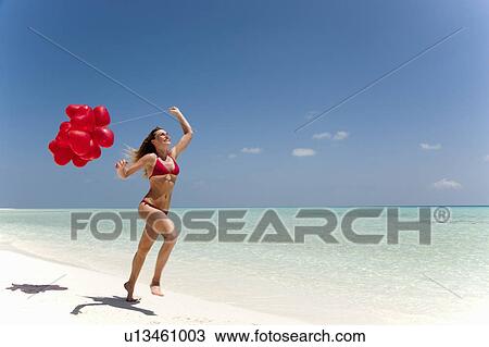 Woman running with balloons on beach View Large Photo Image Stock Image - Woman running with balloons on beach. Fotosearch