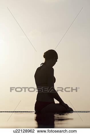 Woman sitting at edge of infinity pool View Large Photo Image Stock Image - Woman sitting at edge of infinity pool. Fotosearch