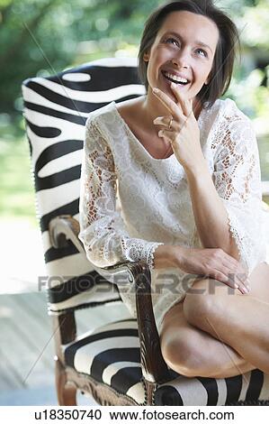 Woman sitting in chair outdoors View Large Photo Image Stock Image - Woman sitting in chair outdoors. Fotosearch