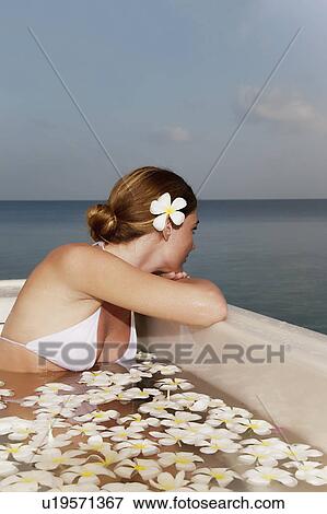 Woman sitting in pool with flowers View Large Photo Image Stock Photo - Woman sitting in pool with flowers. Fotosearch