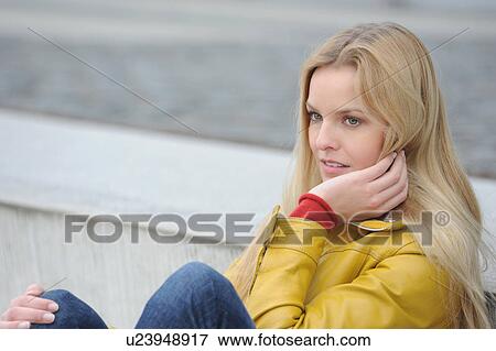 Stock Photo - Woman sitting outdoors. Fotosearch