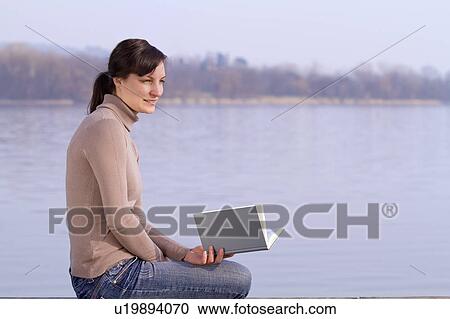 Woman sitting with book outdoors View Large Photo Image Stock Image - Woman sitting with book outdoors. Fotosearch
