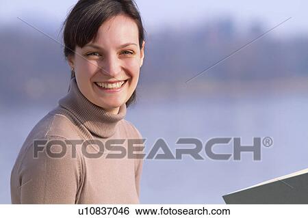 Woman sitting with book outdoors View Large Photo Image Stock Photograph - Woman sitting with book outdoors. Fotosearch