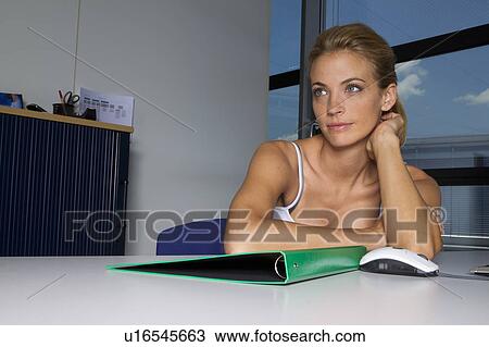 Woman sitting with folder at desk View Large Photo Image Stock Image - Woman sitting with folder at desk. Fotosearch