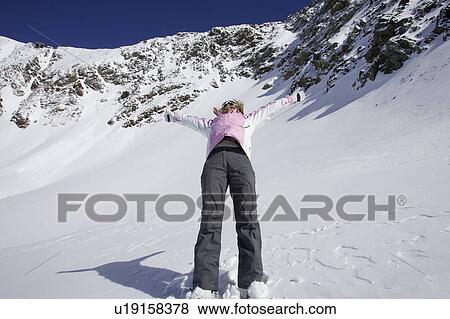 Stock Photo - Woman skiing backwards down slope. Fotosearch