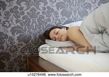 Stock Photograph - Woman sleeping in bed. Fotosearch