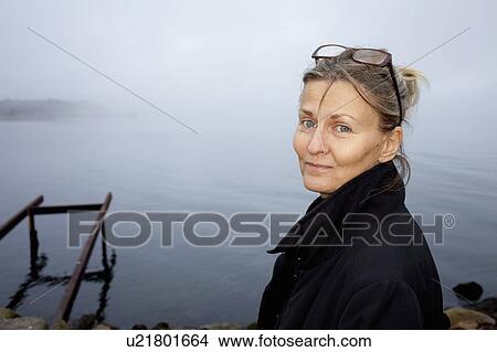 Woman smiling by still lake View Large Photo Image Picture - Woman smiling by still lake. Fotosearch