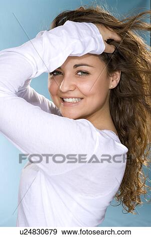 Stock Photo - Woman smiling with hands in hair. Fotosearch