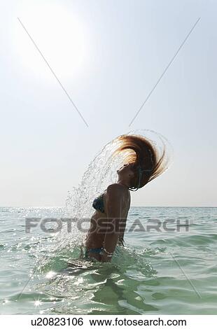 Woman splashing with hair in water View Large Photo Image Stock Photograph - Woman splashing with hair in water. Fotosearch