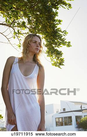 Stock Photography - Woman standing in backyard. Fotosearch