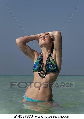 Woman standing in water on beach View Large Photo Image Stock Image - Woman standing in water on beach. Fotosearch