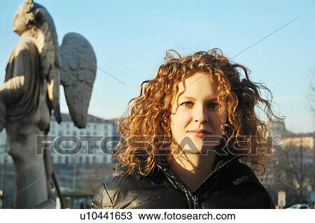 Stock Image - Woman standing on city street. Fotosearch