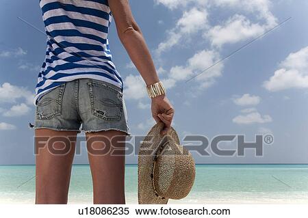Stock Photography - Woman standing on tropical beach. Fotosearch
