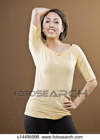 Woman standing with hand behind head View Large Photo Image Stock Photo - Woman standing with hand behind head. Fotosearch