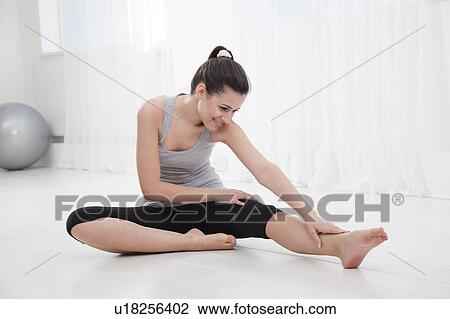 Woman stretching before a workout View Large Photo Image Stock Image - Woman stretching before a workout. Fotosearch