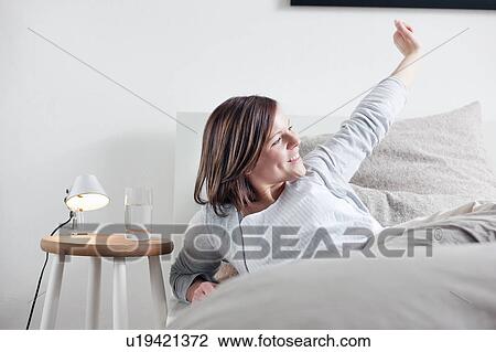 Woman stretching in bed View Large Photo Image Stock Image - Woman stretching in bed. Fotosearch