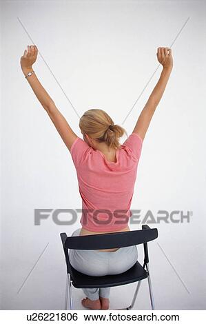 Woman stretching in chair View Large Photo Image Stock Photograph - Woman stretching in chair. Fotosearch