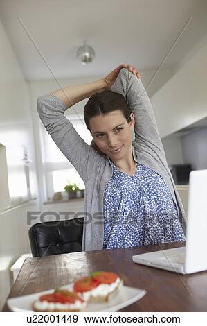 Woman stretching in front of laptop View Large Photo Image Stock Photo - Woman stretching in front of laptop. Fotosearch