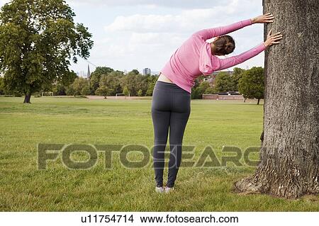 Picture - Woman stretching in park. Fotosearch