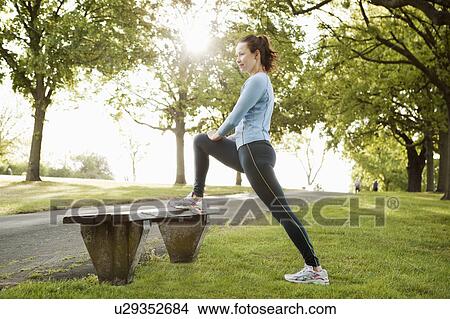 Picture - Woman stretching in park. Fotosearch