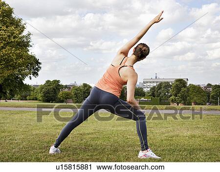 Stock Image - Woman stretching in park. Fotosearch