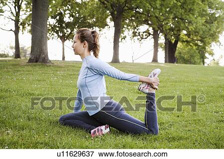 Woman stretching in park View Large Photo Image Stock Photo - Woman stretching in park. Fotosearch