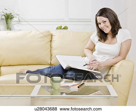 Woman studying on couch View Large Photo Image Stock Photo - Woman studying on couch. Fotosearch