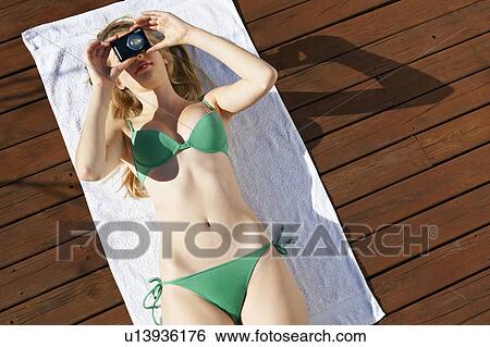 Woman sunbathing and taking pictures View Large Photo Image Stock Photograph - Woman sunbathing and taking pictures. Fotosearch