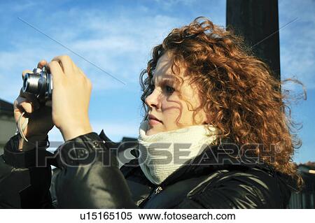 Stock Photography - Woman taking a picture outdoors. Fotosearch